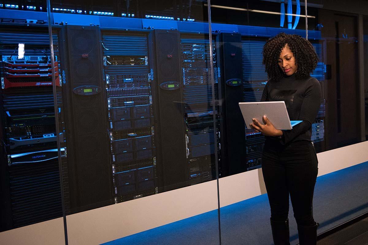 woman standing near servers on computer