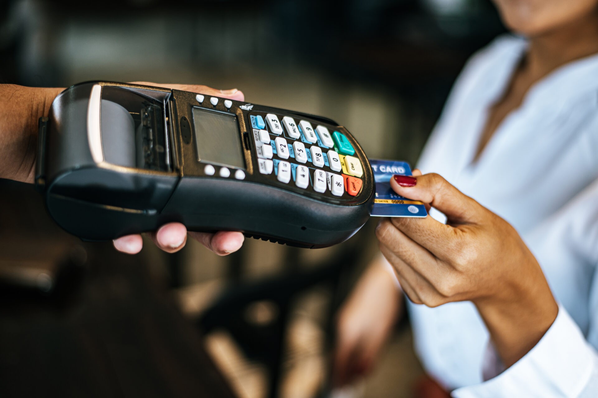 A woman pays with a credit card at a POS terminal. EMV level 3 certification is required for terminals to take smart card payments. We show how we do L3 certification faster.