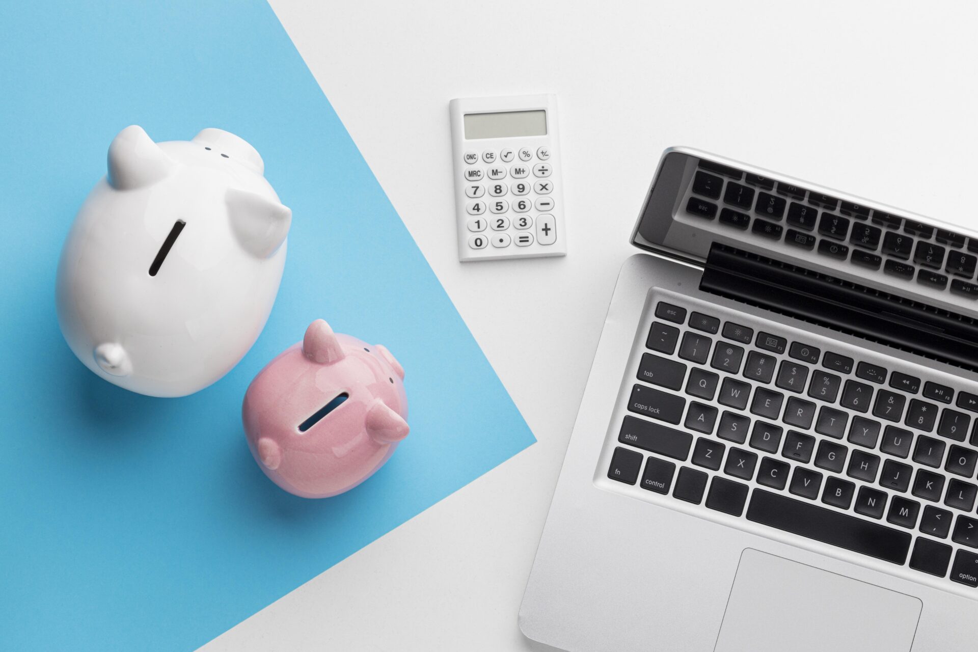 Two piggy banks sit beside a compute. Embedded lending solutions in payment processing platforms is helping merchants access the working capital management solutions they need.
